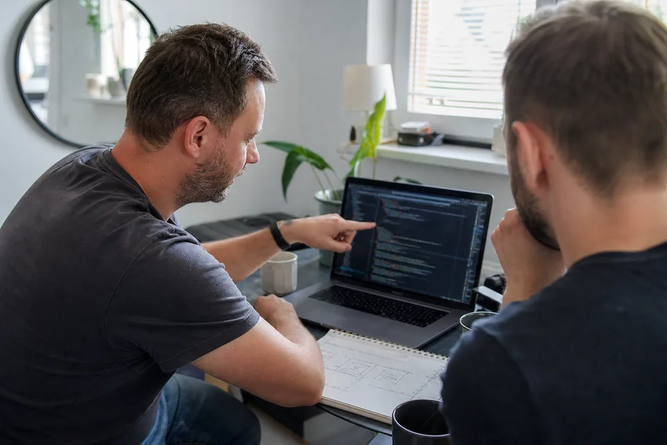 Dwóch programistów omawia przy laptopie wycenę integracji systemu sprzedaży z KSeF